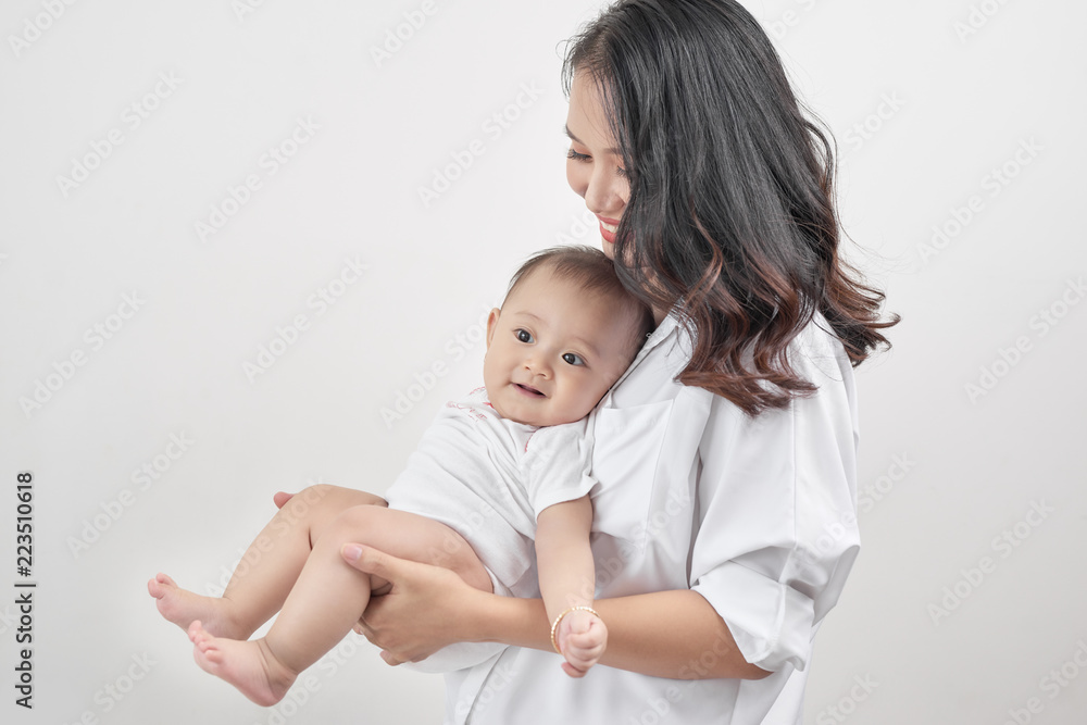 Motherhood and lifestyle concept. Smiling young mother with little baby at home Motherhood and lifestyle concept. Smiling young mother with little baby at home