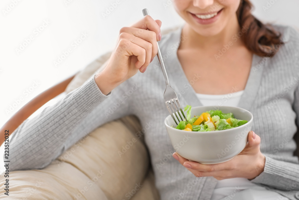 Young woman eating fresh salad at home. Healthy food concept Young woman eating fresh salad at home. Healthy food concept