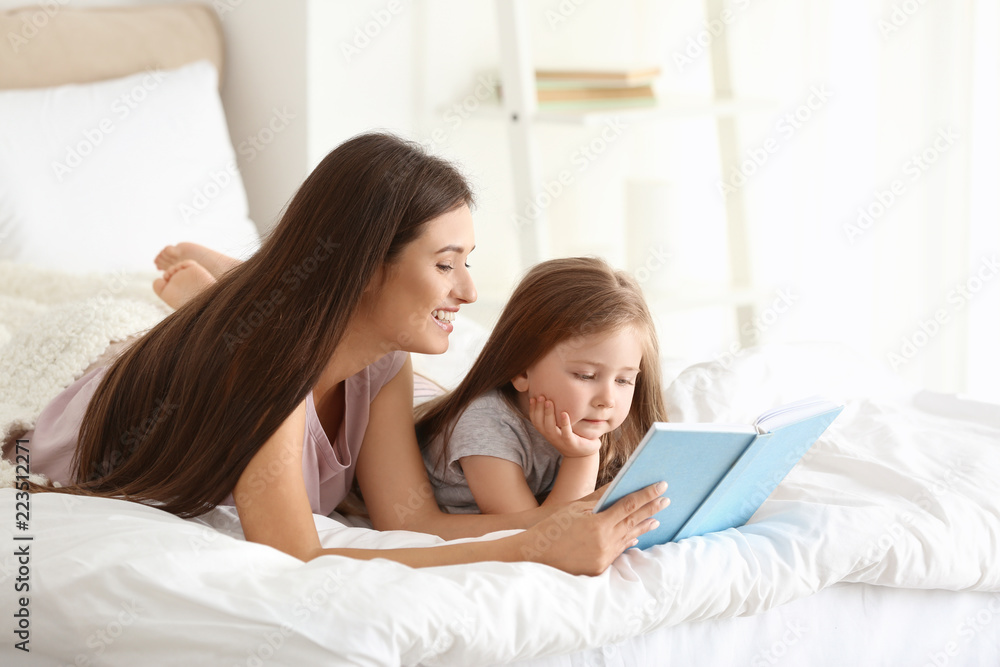 Mother and her daughter reading book together at home Mother and her daughter reading book together at home