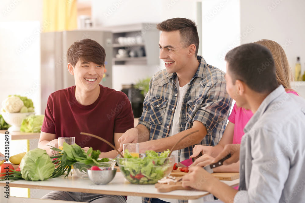 Friends cooking together in kitchen Friends cooking together in kitchen