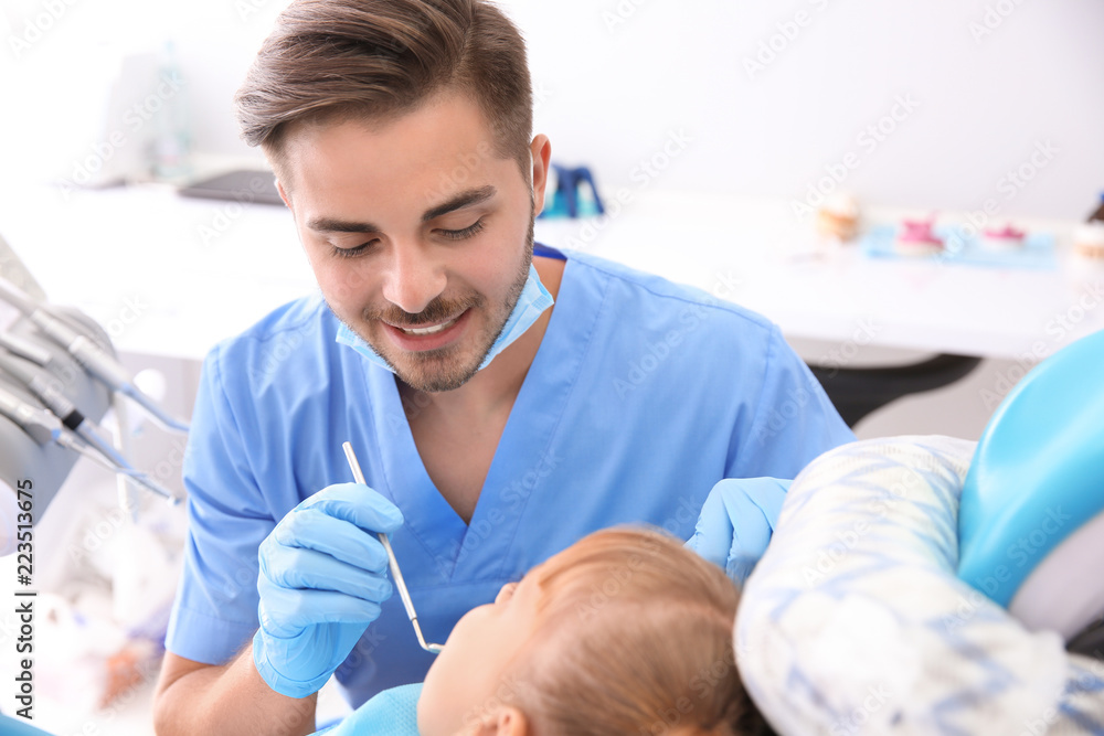 Obraz premium Dentist examining little girl's teeth in clinic