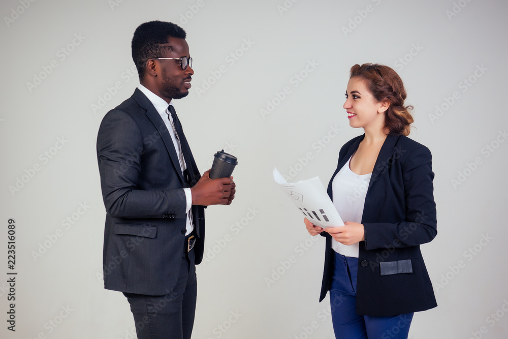 beautiful and young indian woman journalist interviews by African american bank manager owner ceo business man in the studio on a white background beautiful and young indian woman journalist interviews by African american bank manager owner ceo business man in the studio on a white background