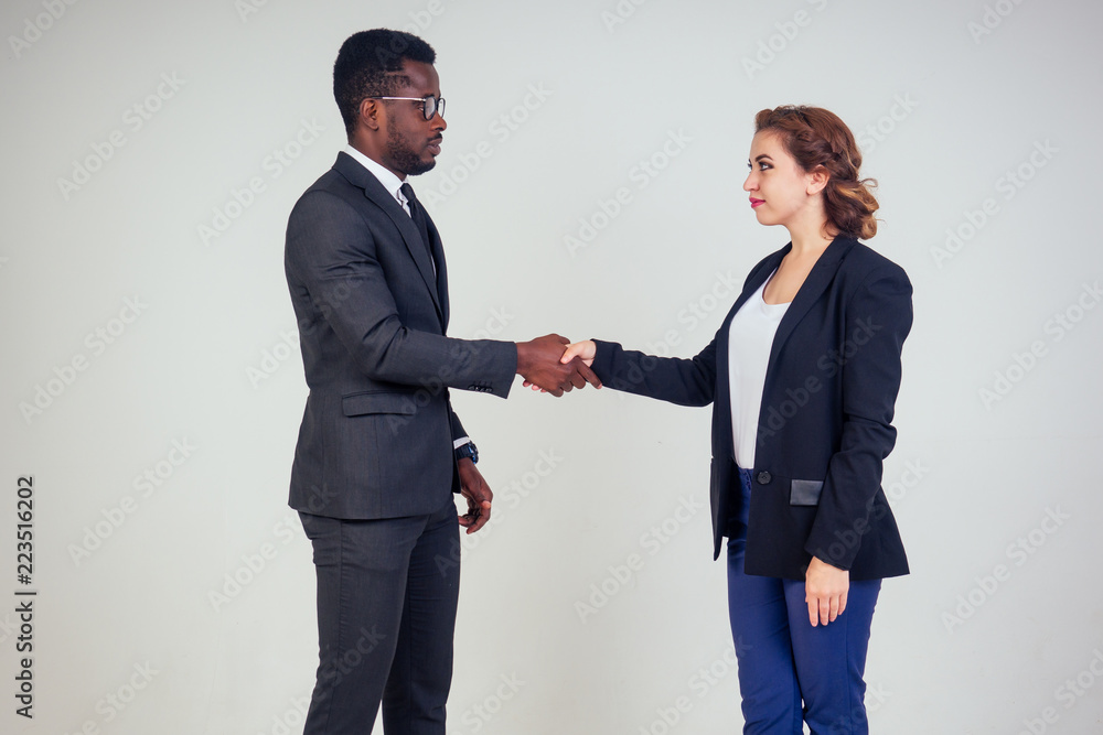 beautiful and young indian woman journalist interviews handshake wiht African american bank manager owner ceo business man in the studio on a white background. multinational teamwork high five beautiful and young indian woman journalist interviews handshake wiht African american bank manager owner ceo business man in the studio on a white background. multinational teamwork high five