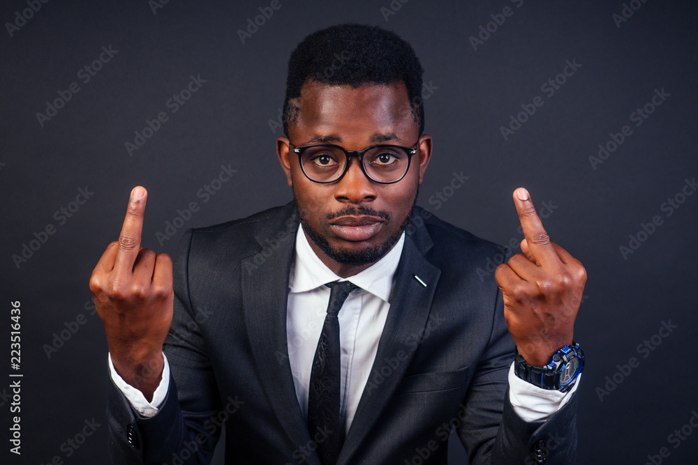 afro american business advisor man showing middle finger to the camera and to you, hand sign confident gesture from the front black background in studio afro american business advisor man showing middle finger to the camera and to you, hand sign confident gesture from the front black background in studio