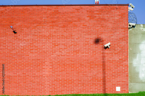Wall of red brick with installed cameras for observation