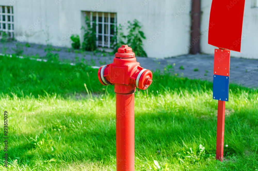 Fire crane red on the green lawn, grass, bushes, security in the city Fire crane red on the green lawn, grass, bushes, security in the city