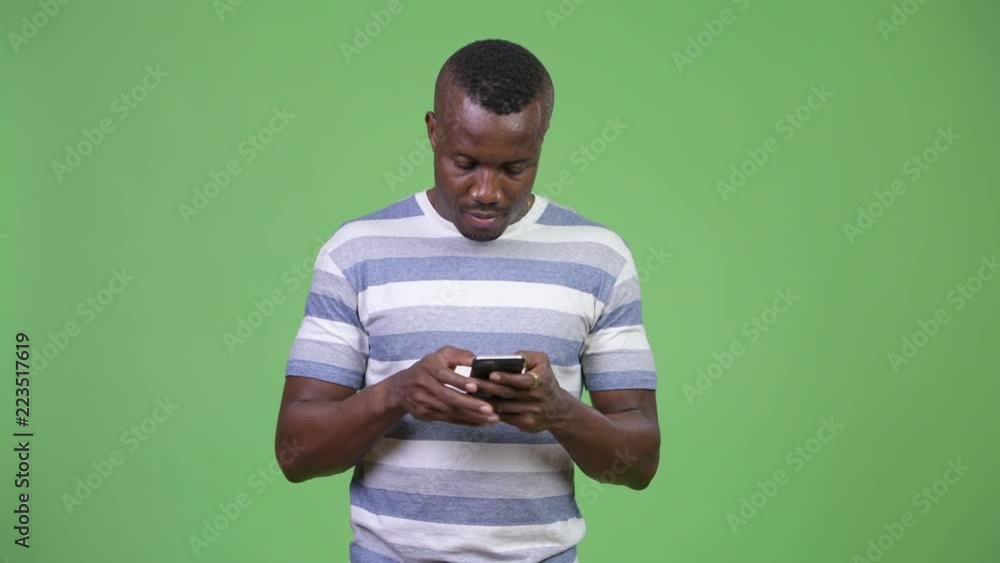 Young happy African man smiling while using phone Young happy African man smiling while using phone