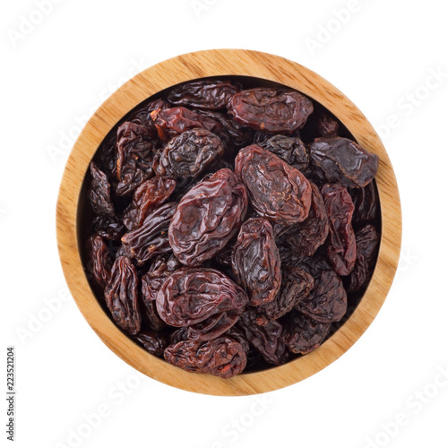 Raisins in wooden bowl isolated on white