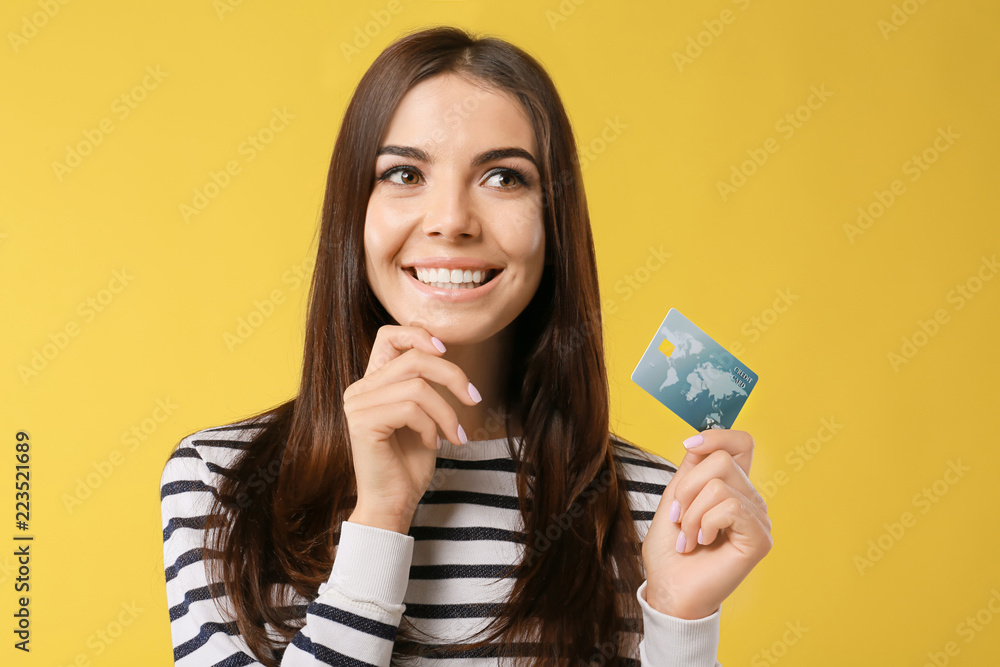 Young woman with credit card on color background. Online shopping Young woman with credit card on color background. Online shopping