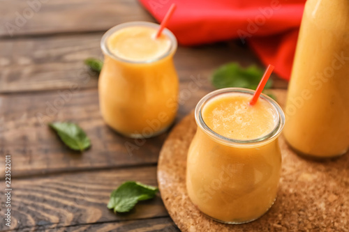 Jars of tasty melon smoothie on wooden table