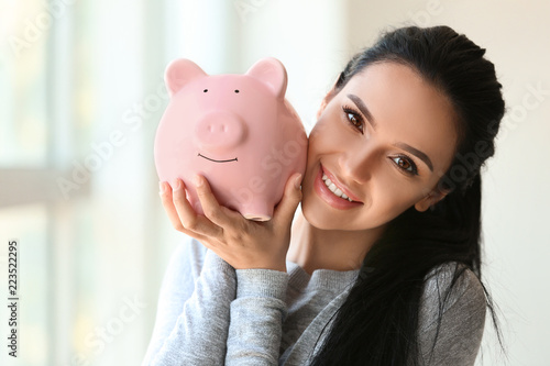 Young woman with piggy bank...