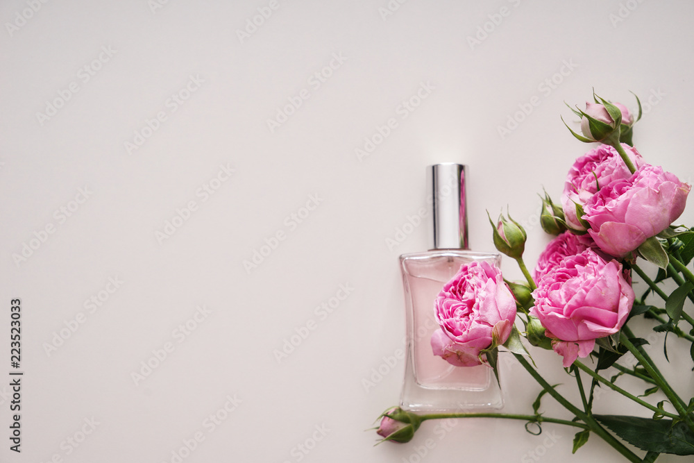 Bottle of perfume with beautiful flowers on white background - obrazy, fototapety, plakaty 
