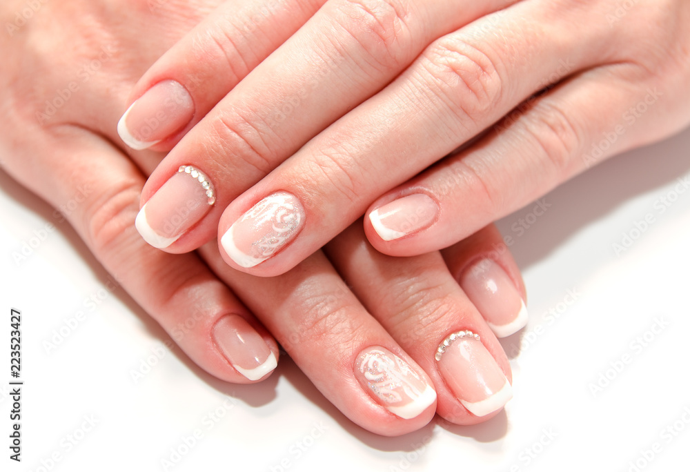 Fototapeta premium Woman's nails with beautiful french manicure fashion design with gems