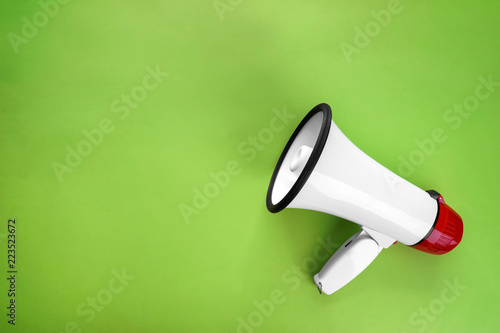 Megaphone on color background