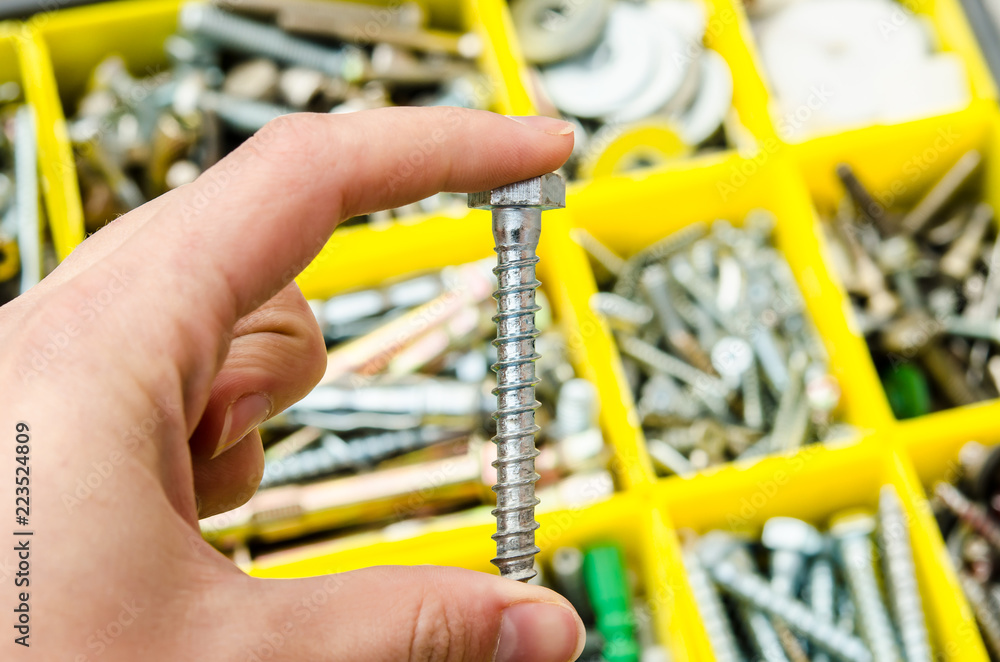 self-tapping screw in hand on the background of tools self-tapping screw in hand on the background of tools