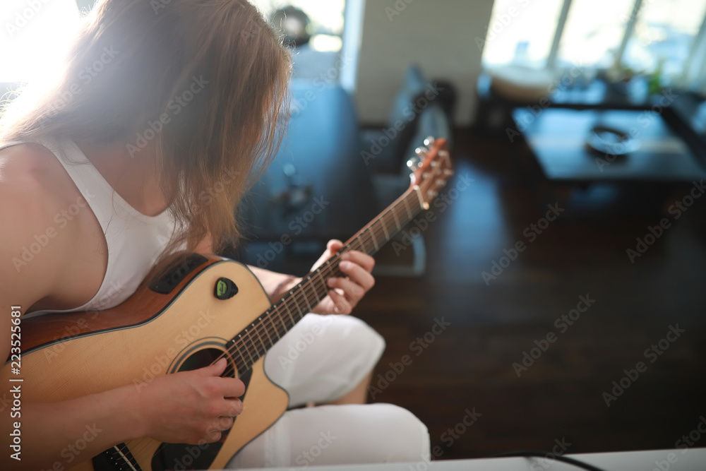 Fototapeta premium Young man with long hair with a guitar