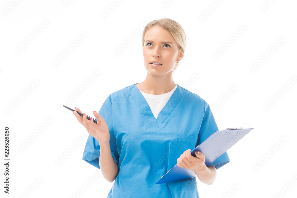 thoughtful young nurse with clipboard and pen looking up isolated on white thoughtful young nurse with clipboard and pen looking up isolated on white