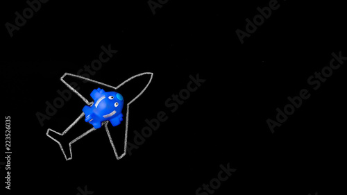 Dream big. Small blue toy airplane on the silhouette of large chalk drawn airliner on black background. Toy plane in dreams of journey. Follow the dream, Dreams Come True, travel, fly concept