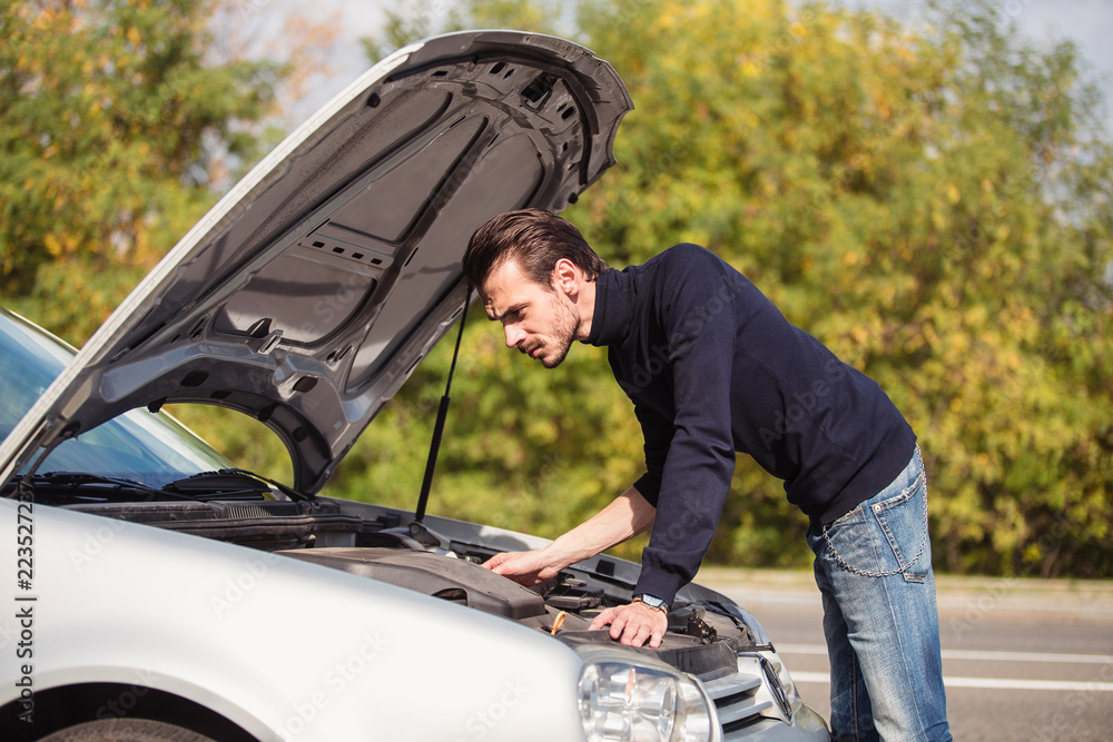 A man tries to repair the car on the road A man tries to repair the car on the road