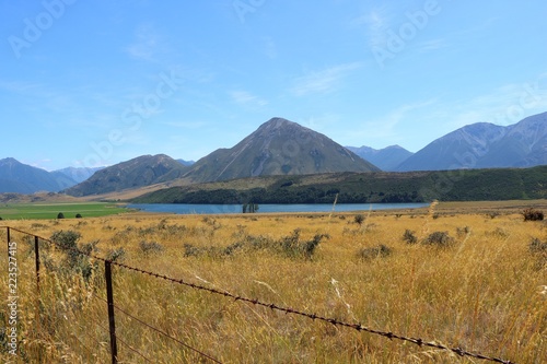 Berg Panorama Landschaft Neuseeland mit See Zaun und Gras photo