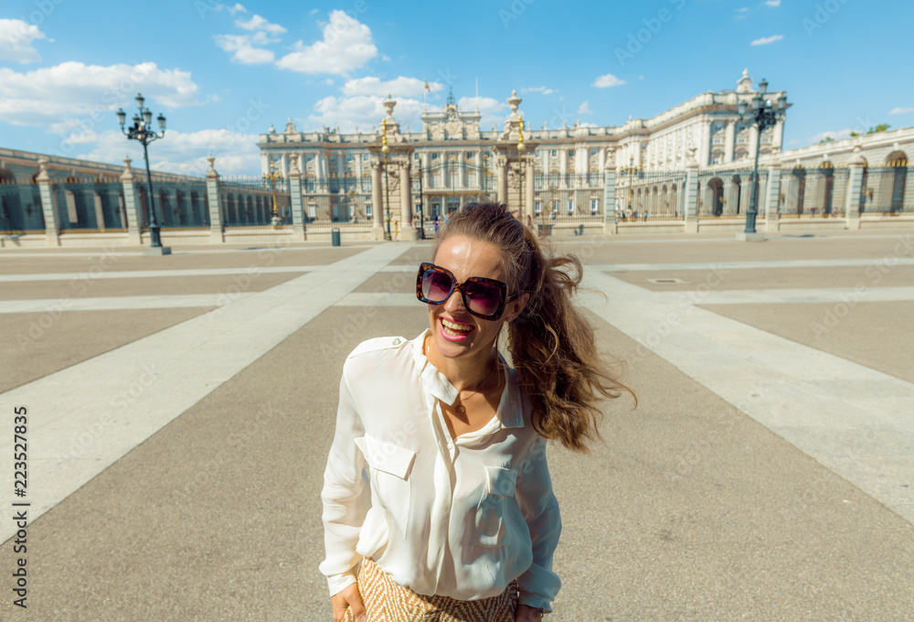 Naklejka premium szczęśliwa nowoczesna kobieta turystycznych w pobliżu Pałacu Królewskiego w Madrycie, Hiszpania