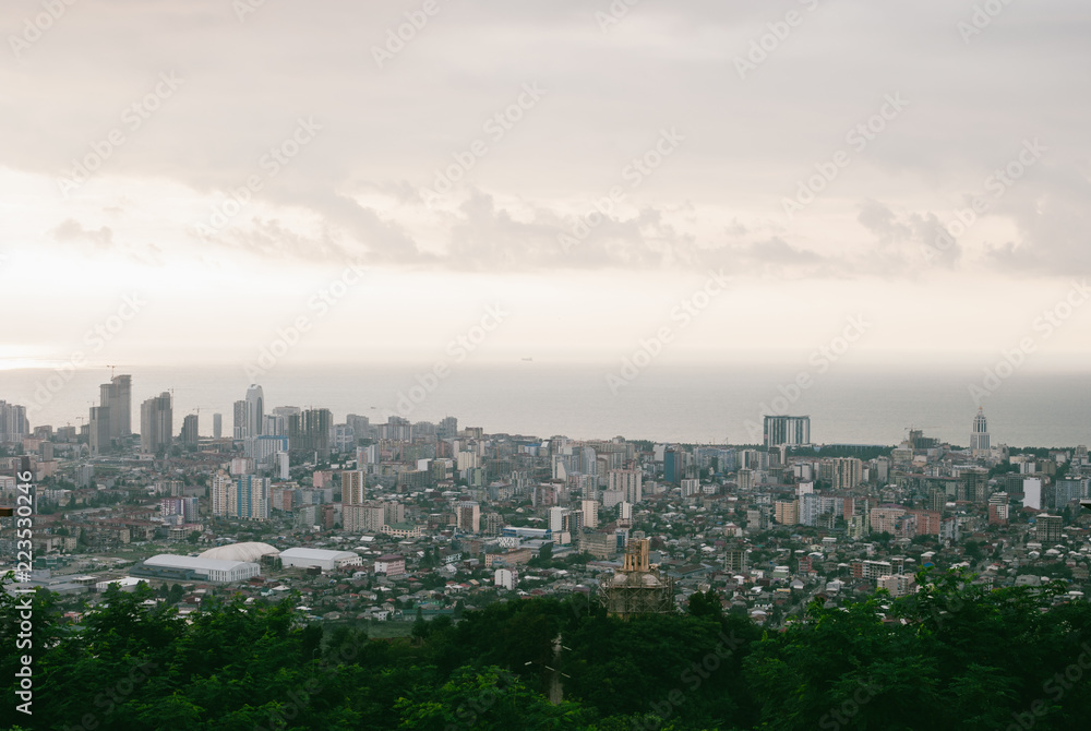 Beatiful colorful Georgian cityscape of Batumi. Panoramic view. Grey clouds over calm Black Sea