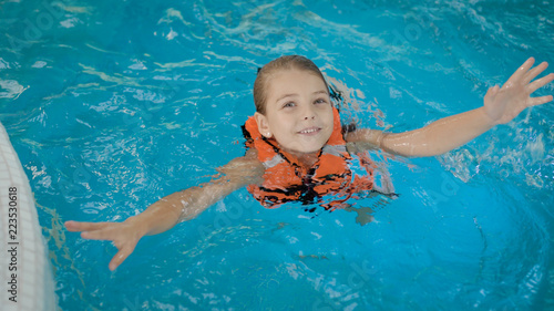Fotografi Girl swimming in life vest