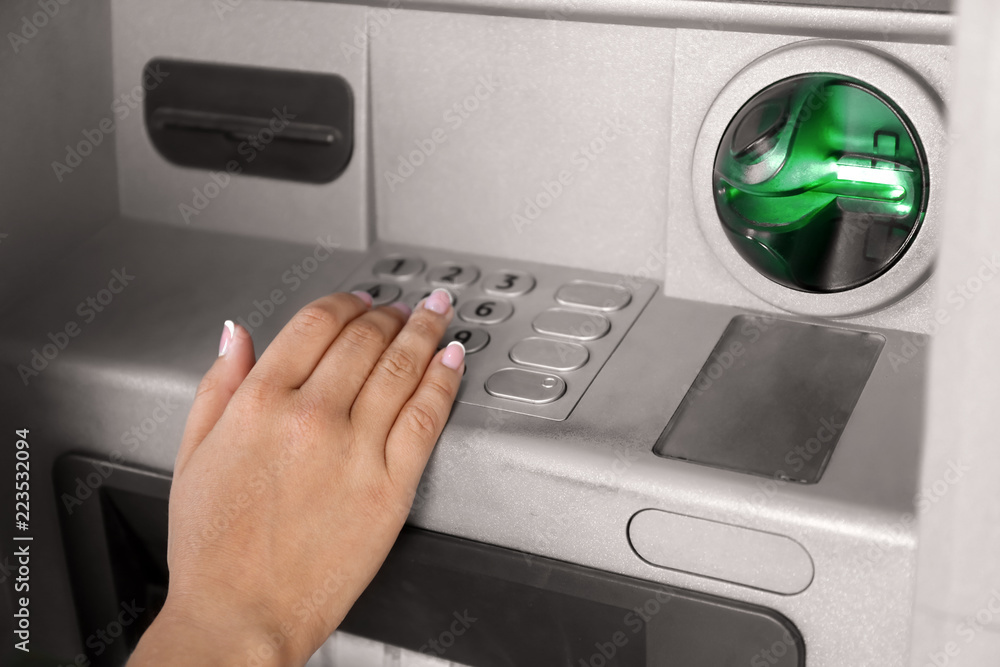 Woman entering PIN code at cash machine, closeup Woman entering PIN code at cash machine, closeup