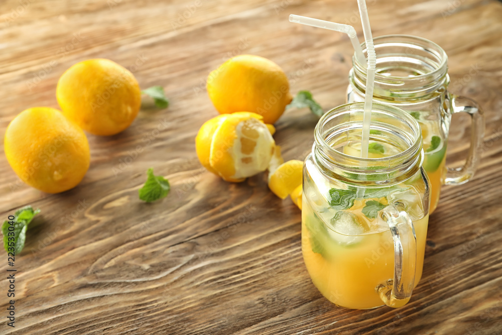 Mason jars of fresh lemon juice on wooden table Mason jars of fresh lemon juice on wooden table