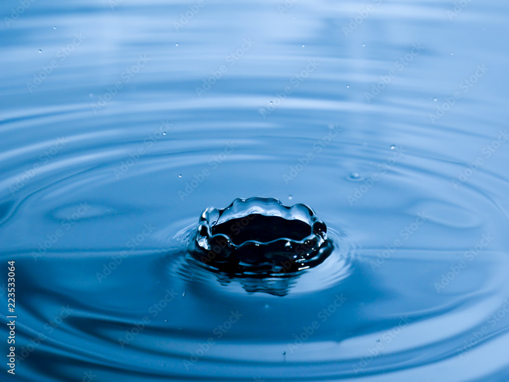 close up drop of water on blue background close up drop of water on blue background