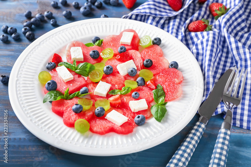 Plate with sweet watermelon salad on wooden table