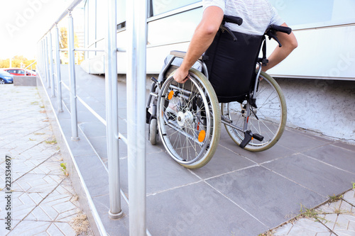 Young man in wheelchair on ramp outdoors photo