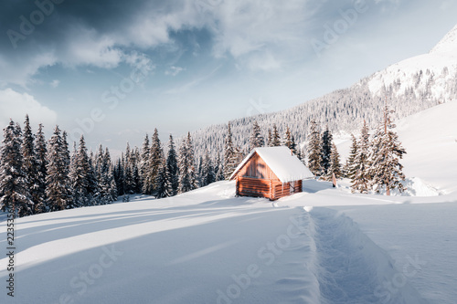 Fantastic winter landscape with wooden house in snowy mountains. Christmas holiday concept. Carpathians mountain, Ukraine, Europe © Ivan Kmit