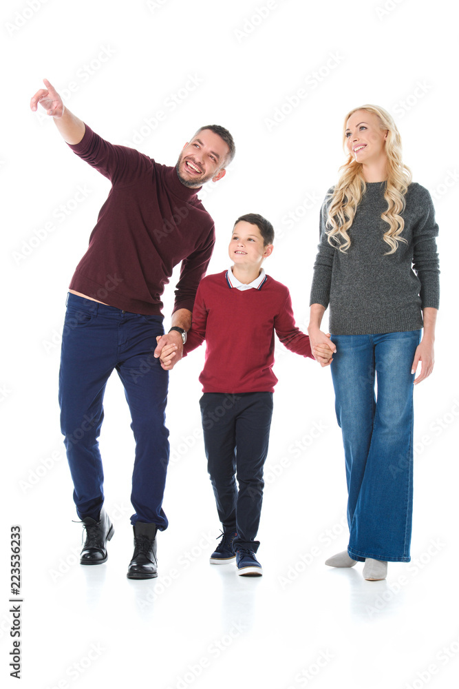 Fototapeta premium family holding hands with son in autumn outfit, man pointing at something isolated on white