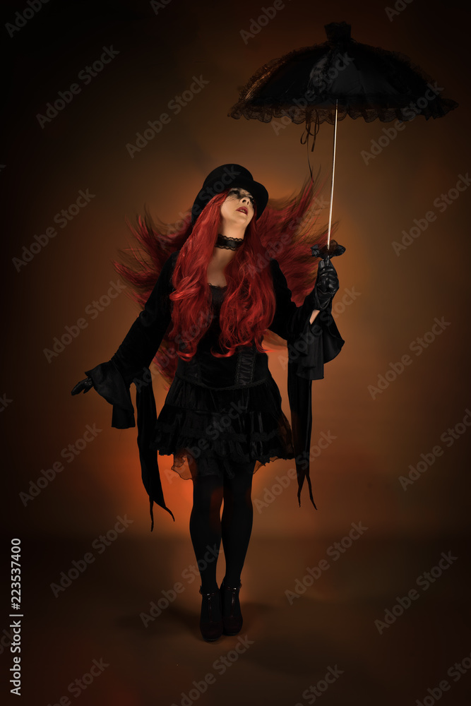 Gótica de pelo rojo posando con sombrilla Stock Photo | Adobe Stock
