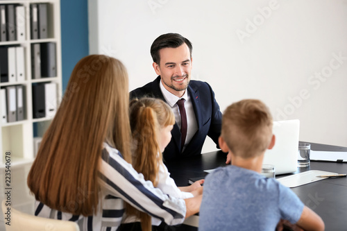 Young woman and her children meeting with headmaster at school