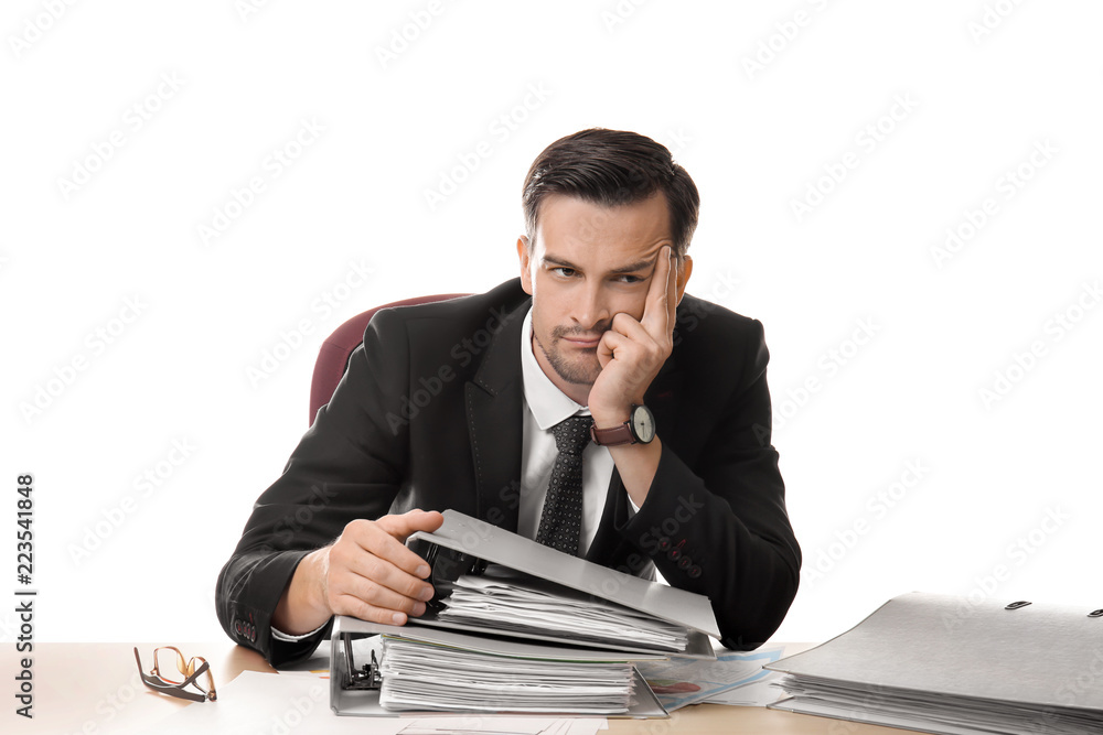 Bored businessman sitting at table with documents against white background Bored businessman sitting at table with documents against white background
