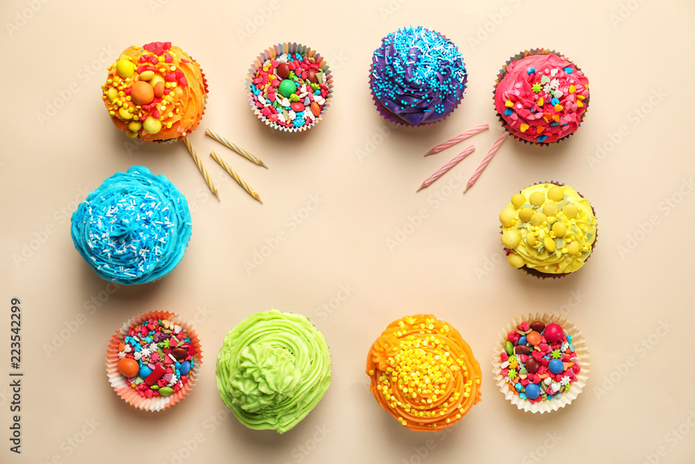 Tasty cupcakes and baking cups with sprinkles on light background Tasty cupcakes and baking cups with sprinkles on light background