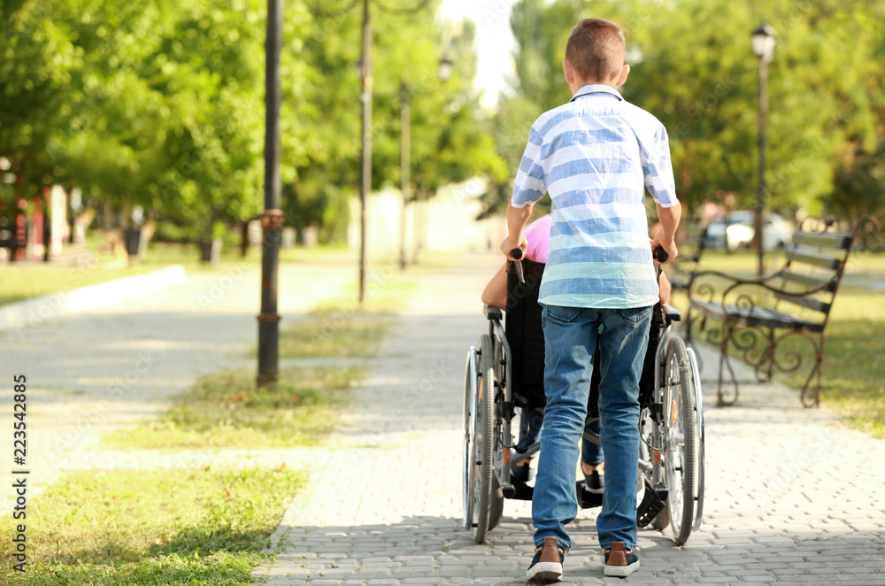 Boy and his handicapped sister resting in park
