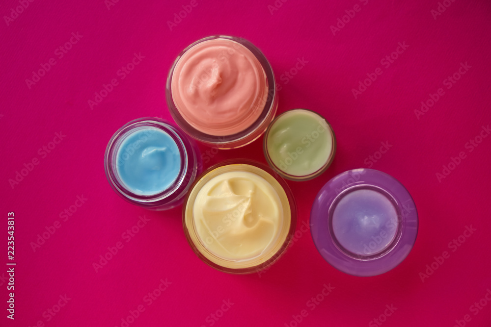 Jars with body cream on color table Jars with body cream on color table