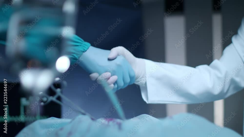 Surgeon doctor handshake. Close up of medical handshake. Surgeon team congratulation after successful operation. Medical handshake concept Surgeon doctor handshake. Close up of medical handshake. Surgeon team congratulation after successful operation. Medical handshake concept