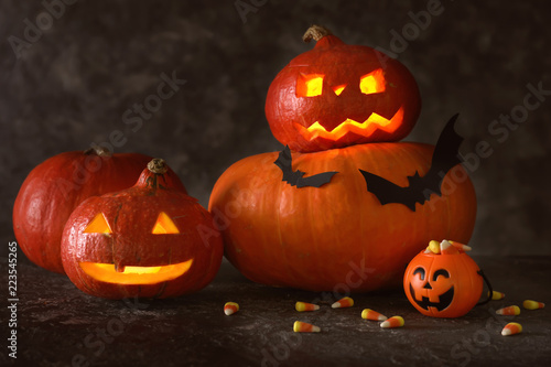 Halloween pumpkins with candies on dark background