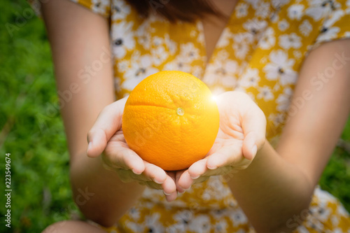 An orange present in girl hands