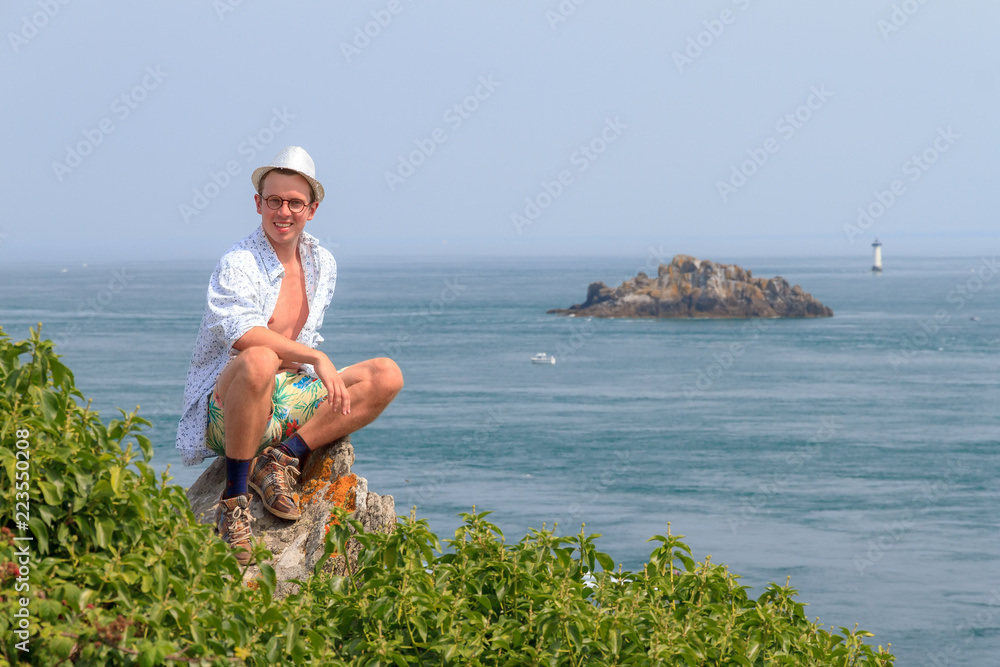 Φωτογραφία Beautiful view of a colorful young tourist on the rocks at Pointe du Grouin near