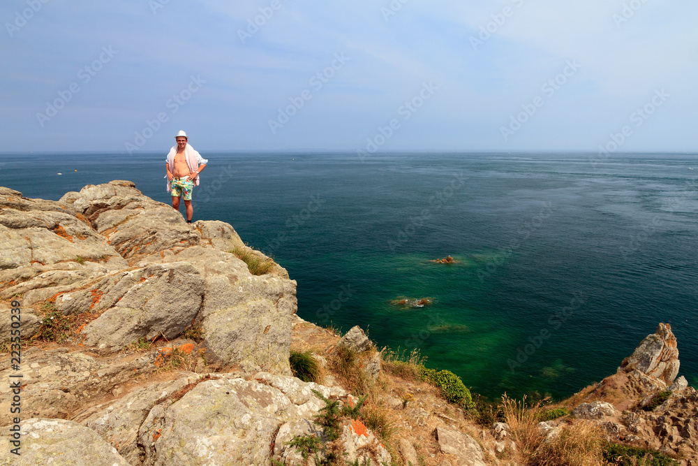 Φωτογραφία Beautiful view of a colorful young tourist on the rocks at Pointe du Grouin near