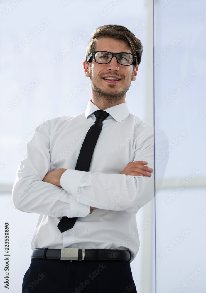 close up.confident businessman standing near the office window close up.confident businessman standing near the office window