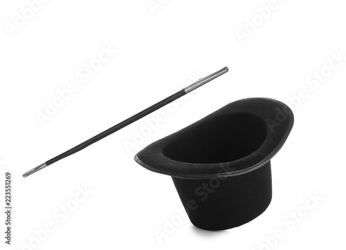 Black hat and magic wand on white background