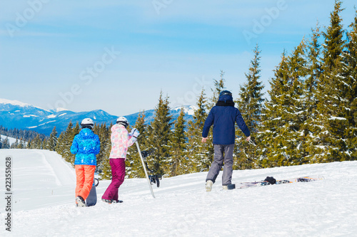 several skiers rest on the top of the mountain. A group of people in ski suits makes selfie on top of the mountain.