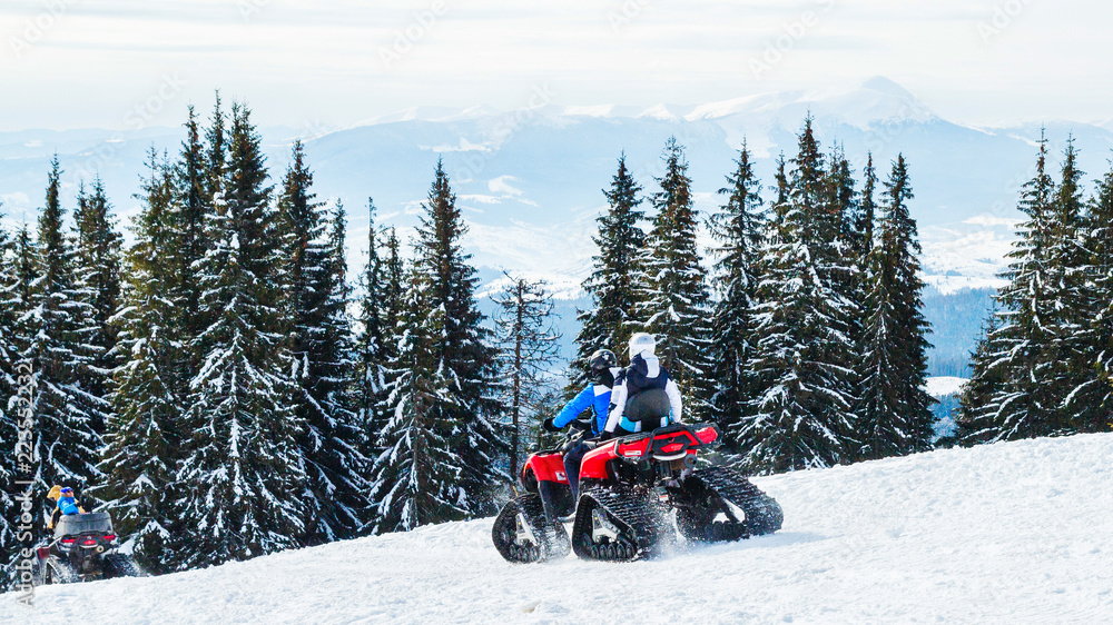 tourists or sportsmen ride mountains on snowmobiles