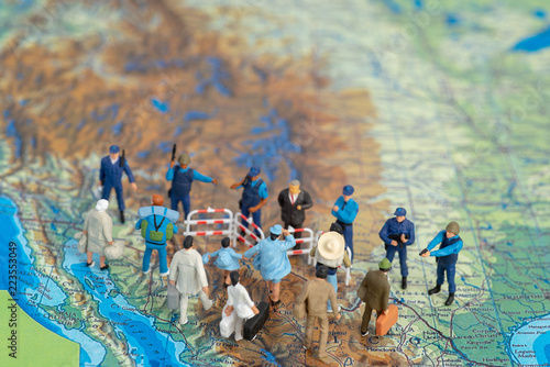 Miniature toy people concept US border patrols against a group of migrant from Mexico photo